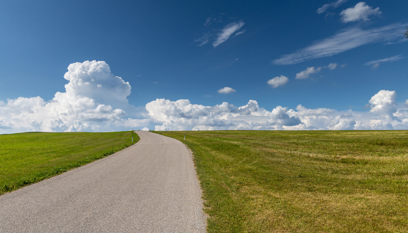 Weiter Weg unter einem großen Wolkenhimmel